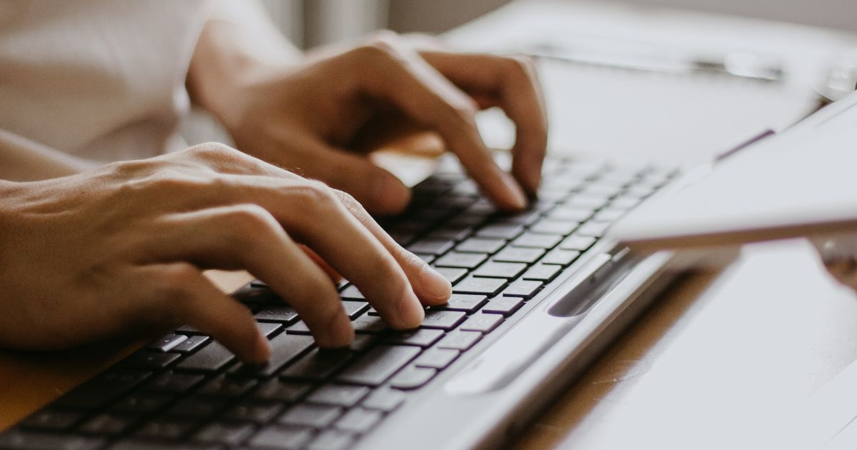 Hands typing on a keyboard