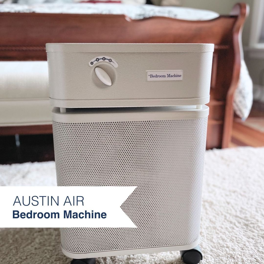 Austin Air Bedroom Machine air purifier on a carpeted floor with furniture in the background
